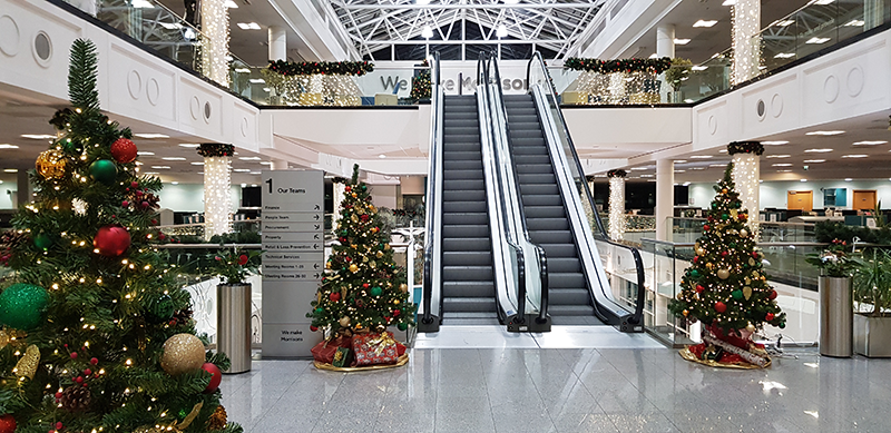 Christmas Trees displayed in the office in the main entrance by the stairs/escalators.